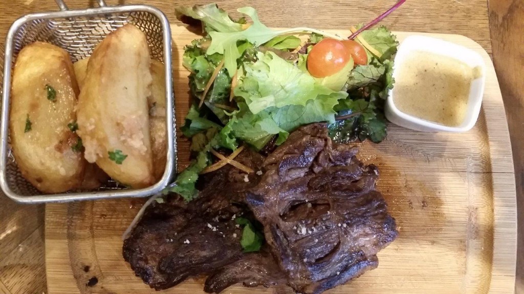 Pièce du boucher sur planche, grosses frites au couteau et légumes 