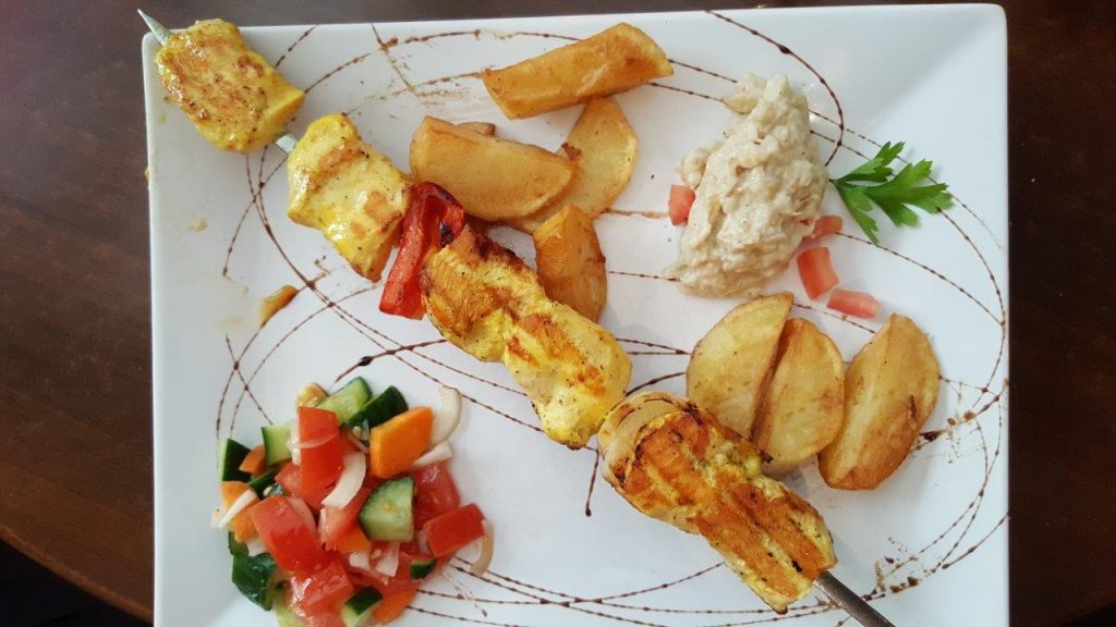 Brochette de poulet, façon caveau, avec caviar d'aubergines, salade, pommes de terre 